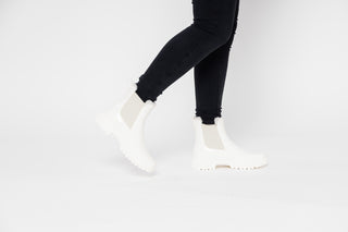 Lemon Jelly, Colden, White patent ankle boot with fluffy insides and cream elastic sides and big thick tread styled with black jeans and modelled with feet and legs, The Shoe Curator