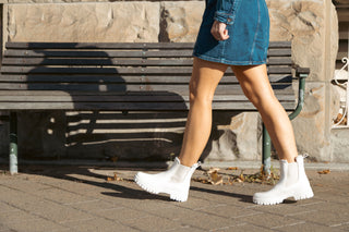 Lemon Jelly, Colden, White patent ankle boot with fluffy insides and cream elastic sides and big thick tread styled with denim skirt and modelled on feet and legs, The Shoe Curator