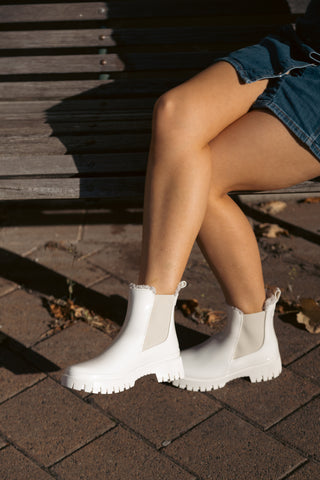 Lemon Jelly, Colden, White patent ankle boot with fluffy insides and cream elastic sides and big thick tread styled with denim skirt modelled on feet and legs, The Shoe Curator