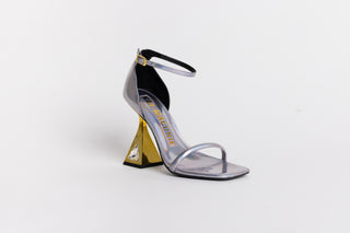 Kat Maconie glossy silver leather sandal heel, with spaghetti strap over the toes and around the ankle. Gold heels stacked on a crystal gem in the heel