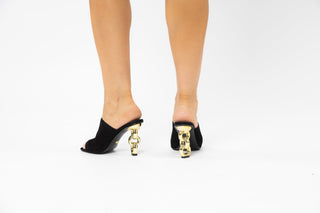 Kat Maconie, Kylie, black suede front cover on a peeped toe high heel with a twisted gold patent heel modelled with feet and legs, The Shoe Curator