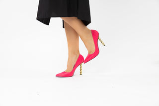 Kat Maconie, Lydia, Hot pink leather stiletto with pointed toes and a twisted gold chain styled with black dress and modelled with legs and feet, The Shoe Curator