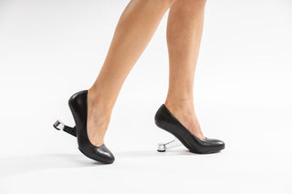 United Nude, Eamz Pump, Black leather patent stiletto with pointed toes and a floating silver heel modelled with feet and legs, The Shoe Curator