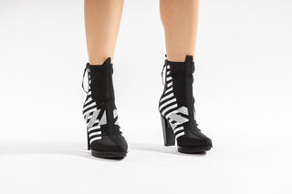 United Nude, Lev Calli Hi, Black and white leather boot with stripes in the middle and black on the front and back with zip, floating small block heel floating modelled with feet and legs, The Shoe Curator