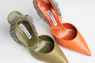 Manolo Blahnik, Skelli, Green leather stiletto with pointed toe and adjustable ankle strap with silver chain detailing modelled with other skelli orange shoe, The Shoe Curator