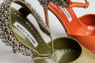 Manolo Blahnik, Skelli, Green leather stiletto with pointed toe and adjustable ankle strap with silver chain detailing modelled with other skelli orange shoe, The Shoe Curator