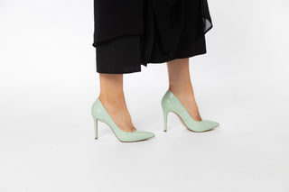 Capelli Rossi pastel green leather pump with pointed toes and stiletto heel styled with black dress and modelled with legs and feet, Rachel, The Shoe Curator