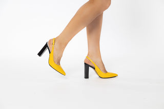 Capelli Rossi yellow high heel with a slingback strap and pointed toes with a black patent block pump heel modelled with feet and legs, Arla, The Shoe Curator.