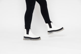 Lemon Jelly, Laney, White patent ankle boot with Black elastic sides and big thick clear tread styled with black jeans modelled with legs and feet, The Shoe Curator