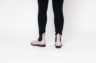 Verbenas, Gaudi, Pastel Pink ankle boot with black elastic sides and big thick black tread styled with black jeans modelled with feet and legs, The Shoe Curator