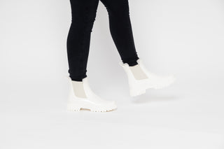 Lemon Jelly, Colden, White patent ankle boot with fluffy insides and cream elastic sides and big thick tread styled with black jeans and modelled with feet and legs, The Shoe Curator