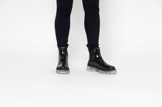 Lemon Jelly, Laney, Black patent ankle boot with black elastic sides and big thick clear tread styled with black jeans modelled with feet and legs, The Shoe Curator