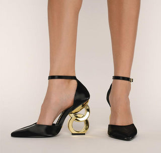 Kat Maconie, Emmi, Black leather heel with pointed toes and thin strap, gold patent chain heel modelled with feet and legs, The Shoe Curator