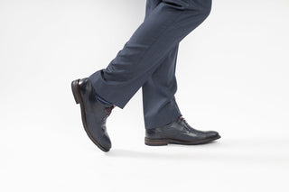 Fluchos, Adrian, Dark blue leather shoe with textured sides and 4 lace holes styled with dress pants and modelled with feet and legs, The Shoe Curator