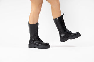 Gioseppo, Kitui, Black leather mid-calf boots with laces up the front and thick black rubber sole modelled with feet and legs, The Shoe Curator