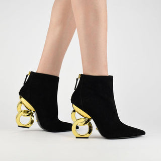 Kat Maconie, Dara, black low cut suede leather boot with pointed toe with zip and gold patent chain heel modelled with legs and feet, The Shoe Curator