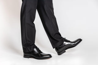 Loake, Bloode, Black patent slim squared toe shoe with classic stitching and laces modelled with feet and legs, The Shoe Curator