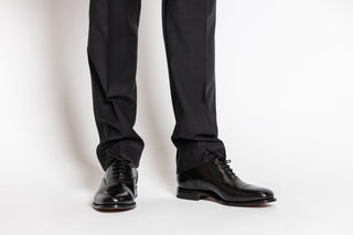 Loake, Bloxto, Black leather patent shoe with slim squared toes and black laces modelled with feet and legs, The Shoe Curator.