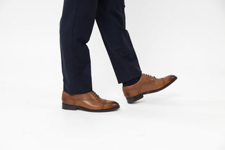 Ted Baker, Arniie, Brown leather male shoe with spot detailing and stitching detailing, brown laces with pointed toes modelled with feet and legs, The Shoe Curator