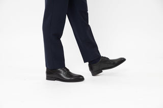 Ted Baker, Kampten, Black leather dinner shoes with pointed toes and black laces styled with dress pants and modelled with feet and legs, The Shoe Curator