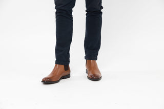 Ted Baker, Maisonn, Brown ankle boots with pointed toes and dark brown elastic on the sides styled with jeans and modelled with feet and legs, The Shoe Curator