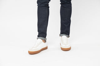 Ted Baker, Robbert, White leather sneakers with tan soles and cream suede details styled with jeans and modelled with feet and legs, The Shoe Curator