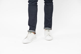 Ted Baker, Udamo, White leather sneaker with white laces and black on the heel styled with jeans and modelled with feet and legs, The Shoe Curator