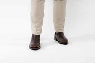 Ted Baker, Maisonn, Brown ankle high boot with pointed toes and elastic on the sides styled with pants and modelled with feet and legs, The Shoe Curator